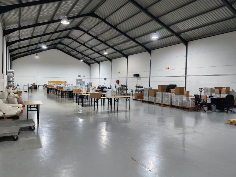 Spacious industrial warehouse featuring high ceilings, steel portal frame construction, and durable epoxy-coated concrete flooring, suitable for manufacturing or storage operations.