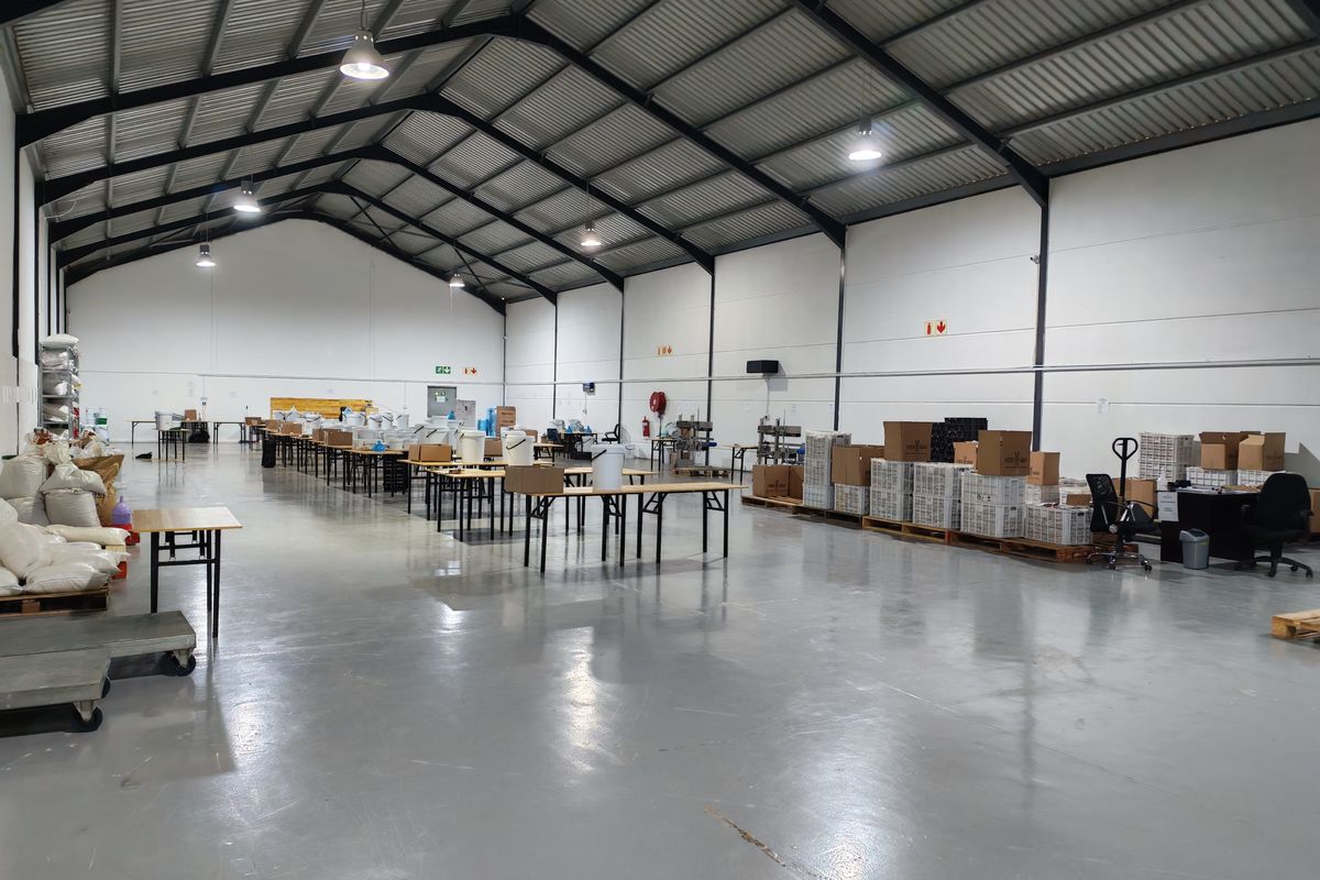 Spacious industrial warehouse featuring high ceilings, steel portal frame construction, and durable epoxy-coated concrete flooring, suitable for manufacturing or storage operations.