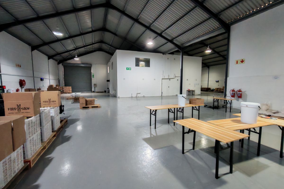 Spacious industrial warehouse unit featuring high ceilings, durable epoxy flooring, a large roller shutter door, and essential fire safety equipment.
