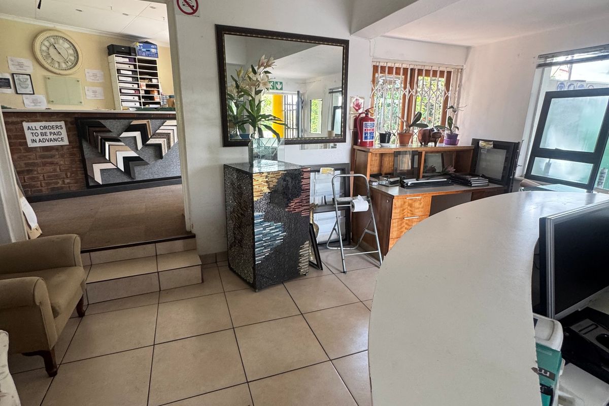 Commercial reception area featuring a built-in desk, tiled flooring, and split-system air conditioning, providing a functional workspace for client interactions.