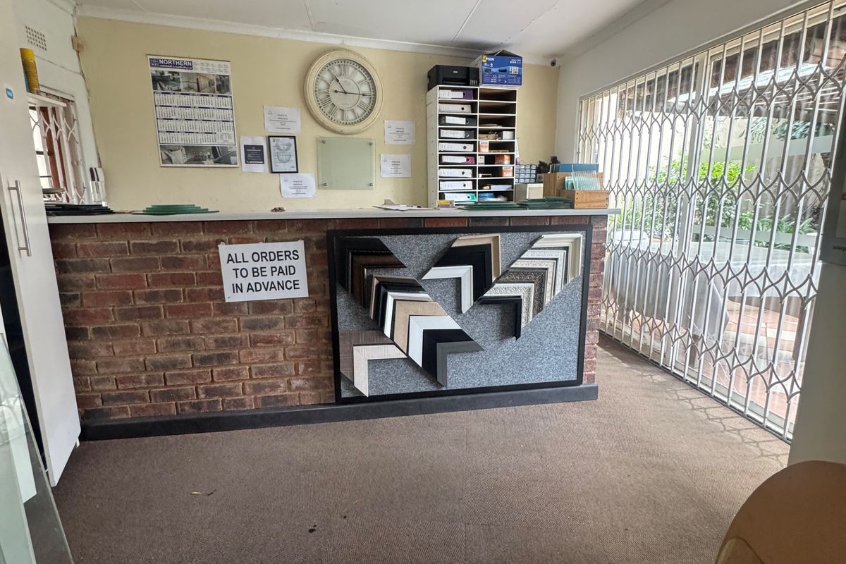 Commercial reception area featuring a brick counter, security gate, and recessed lighting, suitable for a professional office or retail storefront.