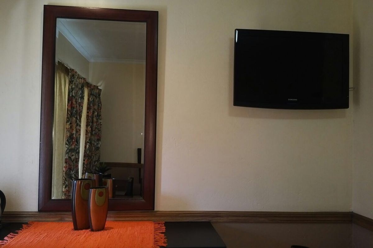 A bedroom wall featuring a mounted television, decorative wooden dado rail, and coving detail.