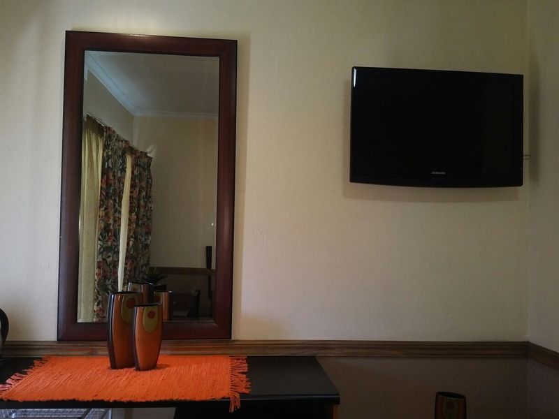 A bedroom wall featuring a mounted television, decorative wooden dado rail, and coving detail.