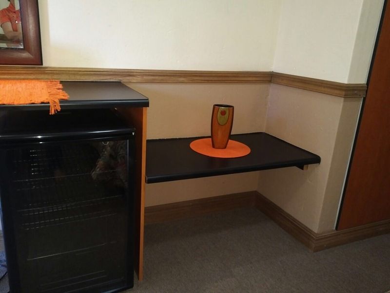 A small utility area featuring built-in shelving and a compact under-counter unit, finished with traditional chair rail and skirting board detailing.