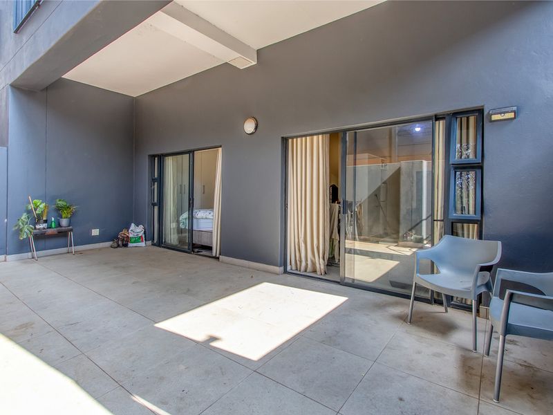 A covered patio area featuring tiled flooring and sliding glass doors providing access to the interior living spaces.