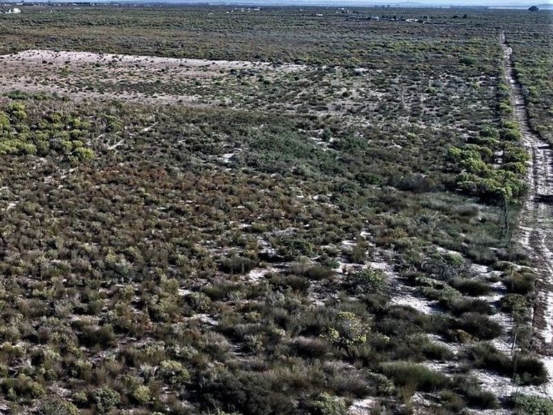 An aerial view of the expansive, undeveloped small holding land featuring natural vegetation and a dirt access track.