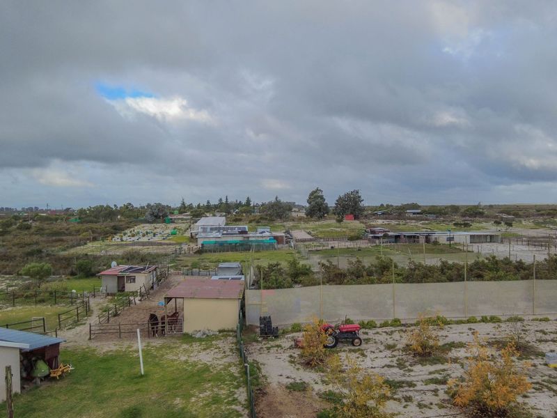 Aerial view of the small holding property, showcasing the expansive grounds, various outbuildings, fenced paddocks, and surrounding landscape.
