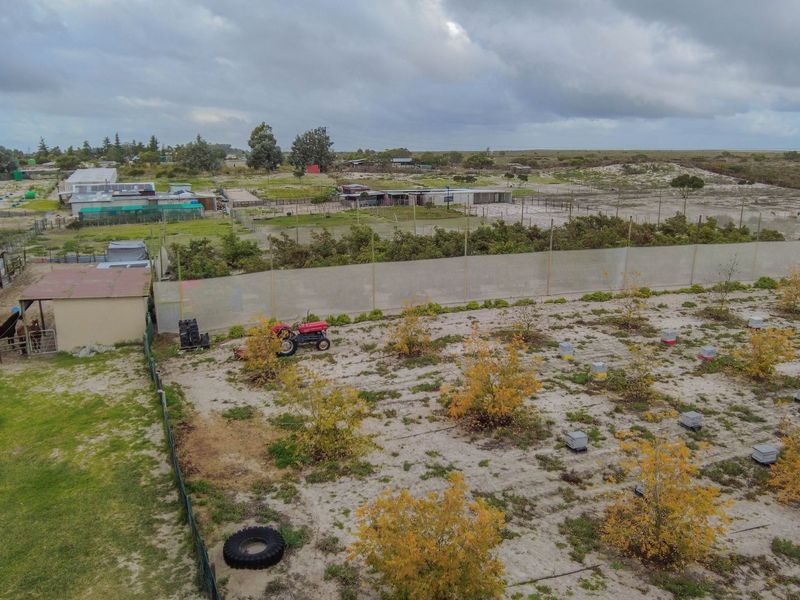 Aerial view of the small holding property featuring open land, perimeter fencing, and various outbuildings suitable for agricultural or livestock use.