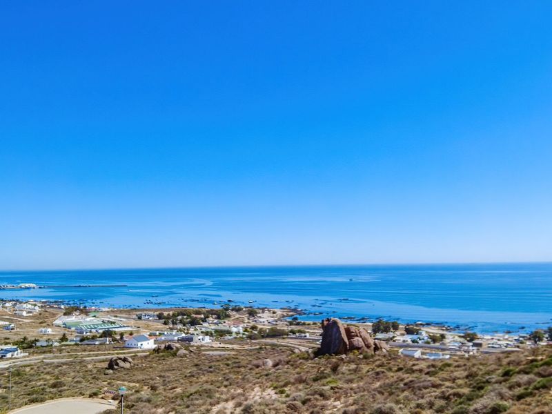 A scenic elevated view overlooking the coastal landscape, ocean, and surrounding residential area.