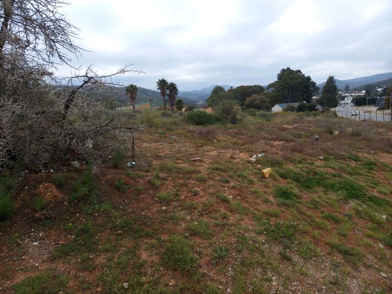 A view of a vacant residential plot featuring natural vegetation and surrounding landscape, suitable for future development.