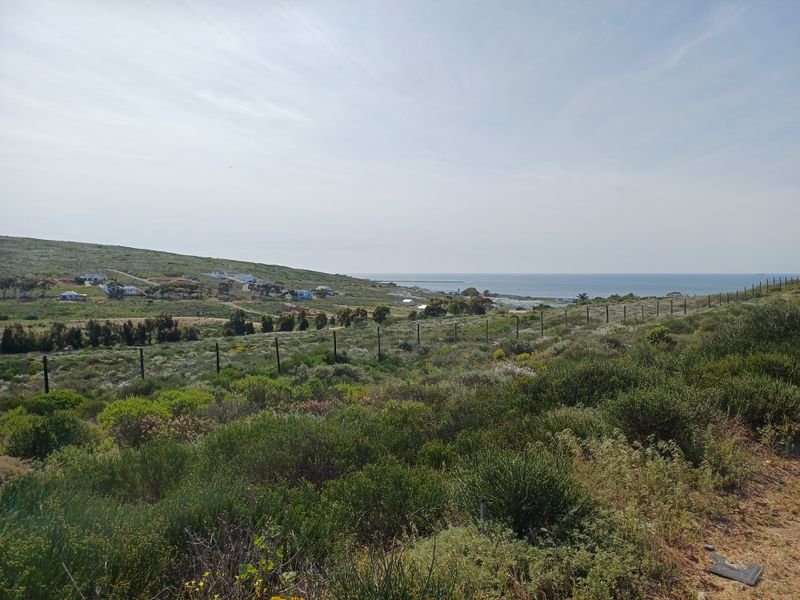 A scenic view of the coastal landscape and surrounding residential area from the vacant residential plot.