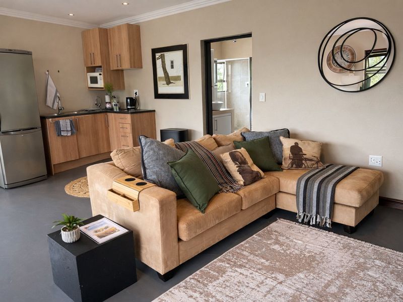 Open-plan living area featuring a compact kitchenette with wood-finish cabinetry and a seamless flow into the lounge space.