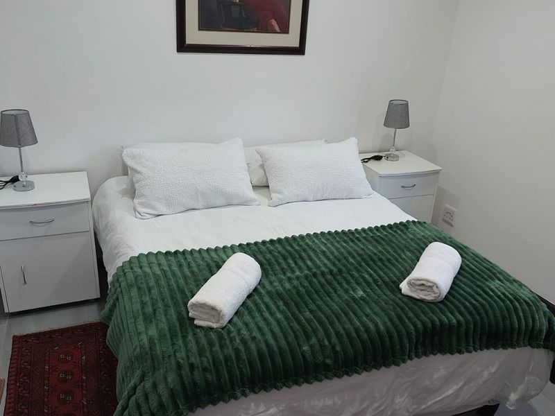 A simple, functional bedroom featuring neutral walls and tiled flooring, providing a clean and comfortable sleeping space.