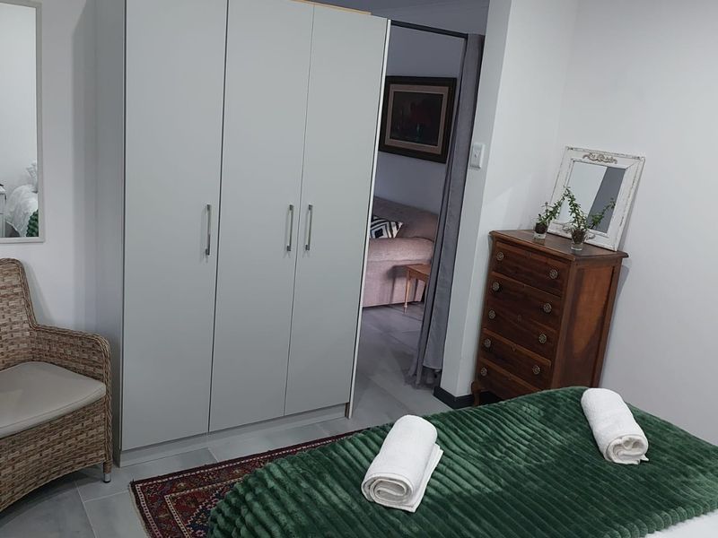 A well-maintained bedroom featuring a modern built-in wardrobe and neutral finishes, providing a clean and functional living space.
