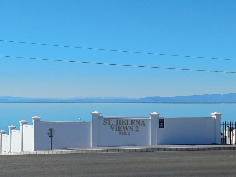 Front entrance view of St. Helena Views 2 residential estate featuring a clean boundary wall and clear signage overlooking the ocean.