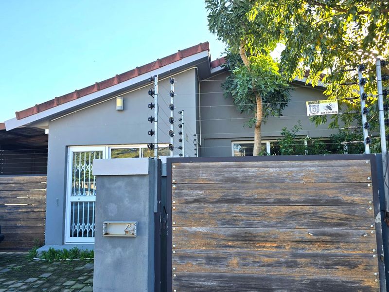 Front exterior view of the property featuring a secure entrance with electric fencing, a timber gate, and a tiled roof.