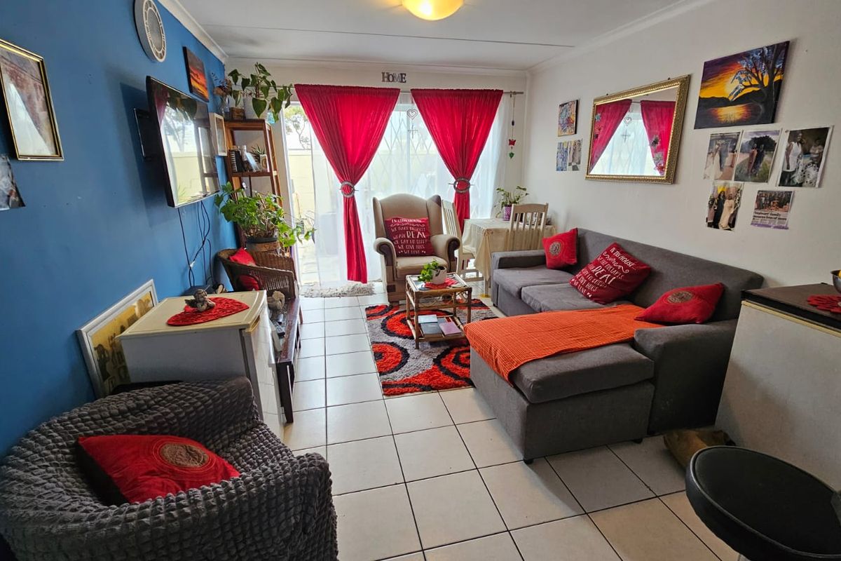 A living room featuring tiled flooring and a sliding glass door providing access to the outdoor area.