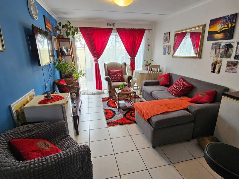 A living room featuring tiled flooring and a sliding glass door providing access to the outdoor area.