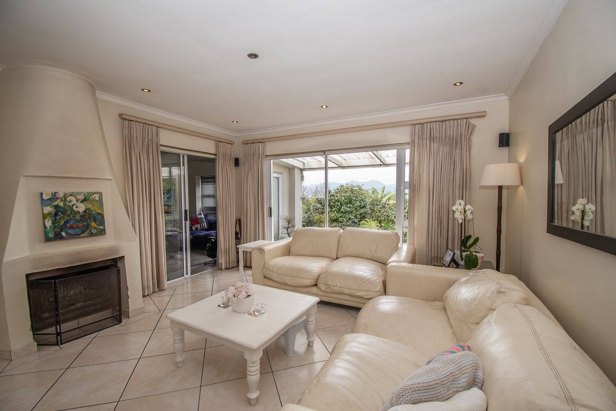 Spacious living room featuring a built-in fireplace, tiled flooring, and large sliding glass doors providing natural light and access to the outdoor area.