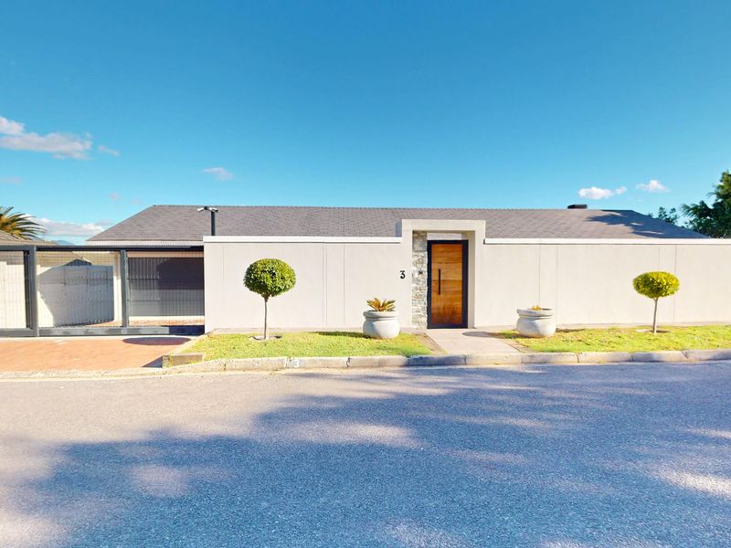 Modern front facade featuring a clean rendered boundary wall, stone-clad entrance detail, timber front door, and secure sliding gate access.