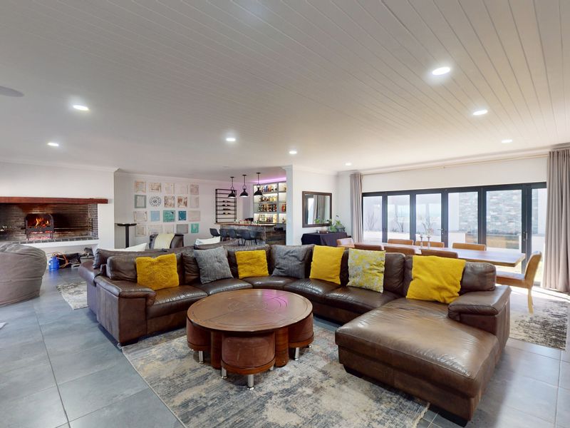 Spacious open-plan living area featuring a built-in fireplace, integrated bar, and large bi-fold doors leading to the exterior.