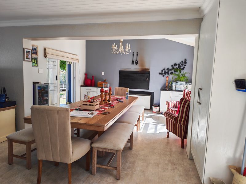 Open plan dining and living area featuring a built-in fireplace, timber-look flooring, and direct access to the outdoor patio through sliding glass doors.