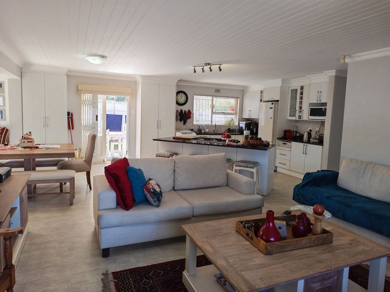 Spacious open-plan living area featuring a modern kitchen with island, gas hob, and integrated appliances, flowing seamlessly into the dining and lounge space.