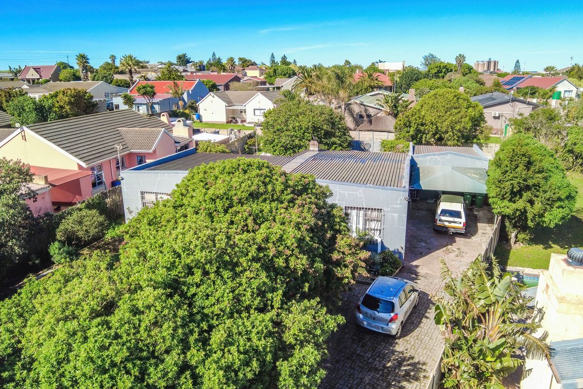 Aerial view of the property showing the roof structure, paved driveway, carport, and surrounding residential neighbourhood.