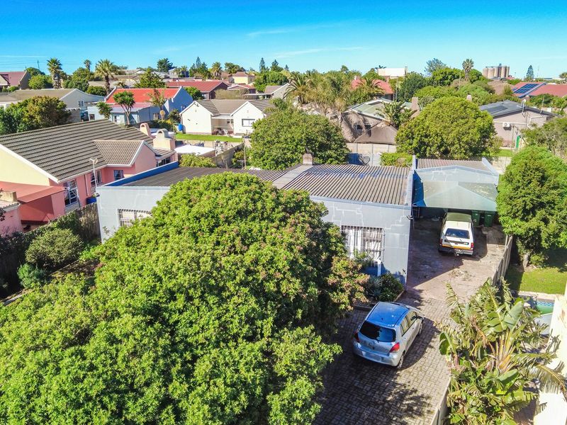 Aerial view of the property showing the roof structure, paved driveway, carport, and surrounding residential neighbourhood.