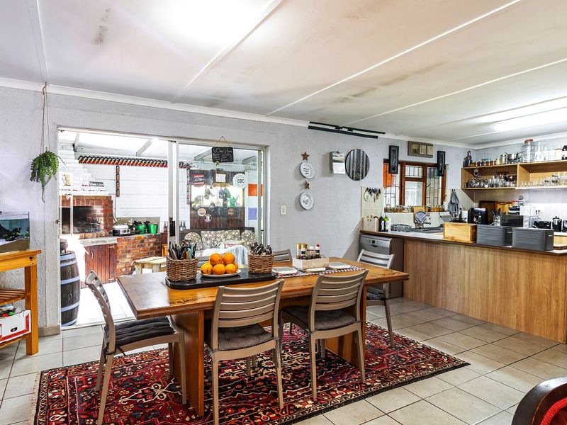 Open-plan kitchen and dining area featuring tiled floors, built-in cabinetry, and direct access to an outdoor patio through sliding glass doors.
