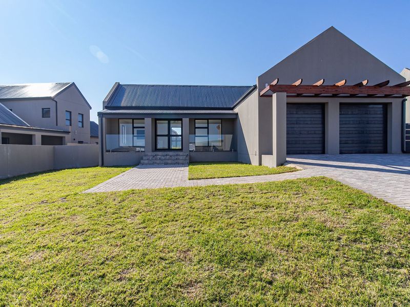 Modern single-story residence featuring a double garage, paved driveway, timber pergola, and a clean, contemporary facade with glass balustrades.