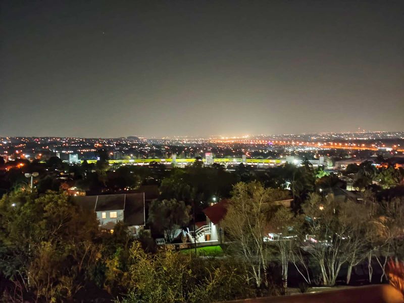 A night-time elevated view overlooking the surrounding residential neighbourhood and distant city lights.
