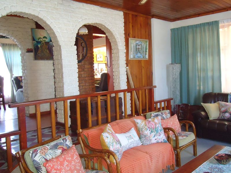 A living room featuring distinctive brick archways, timber wall paneling, and a timber ceiling, creating a traditional and warm atmosphere.