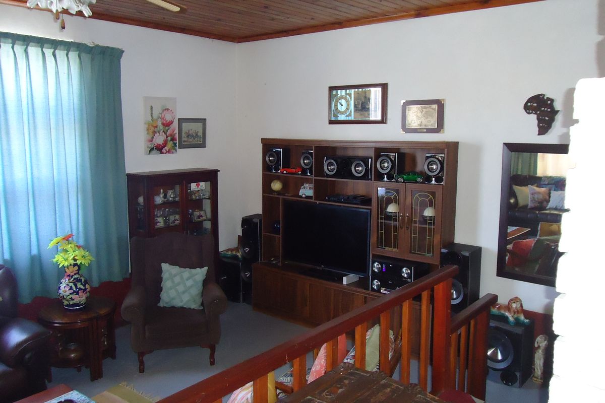 A living room featuring a timber ceiling and a wooden balustrade overlooking a lower level, providing a traditional and cozy atmosphere.