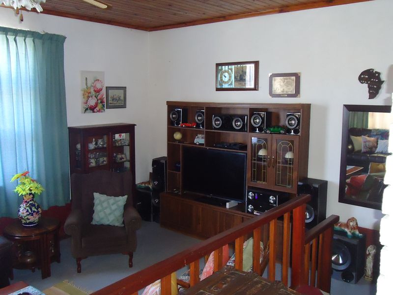 A living room featuring a timber ceiling and a wooden balustrade overlooking a lower level, providing a traditional and cozy atmosphere.