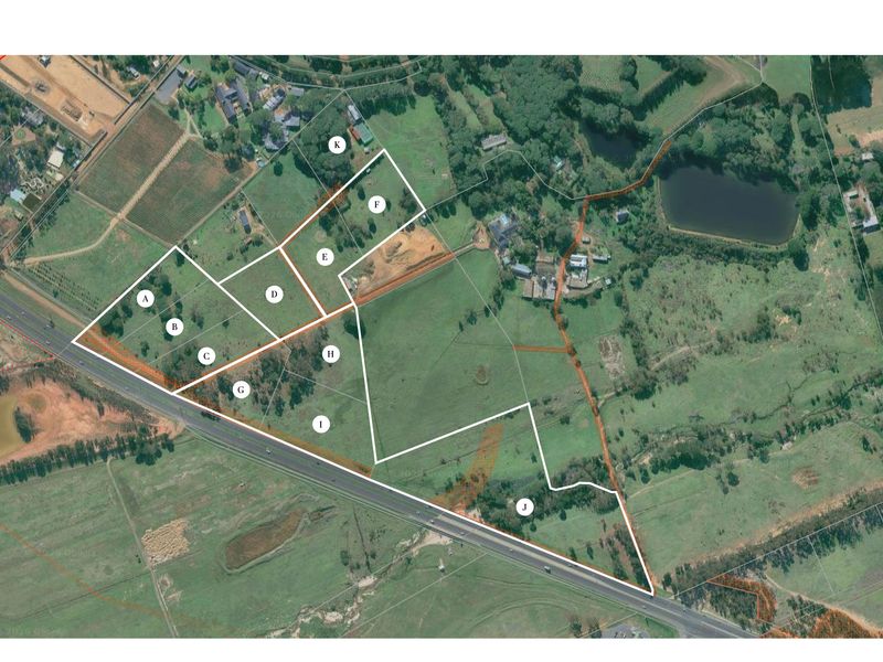 An aerial view showing multiple residential land parcels with marked boundaries and access road infrastructure.