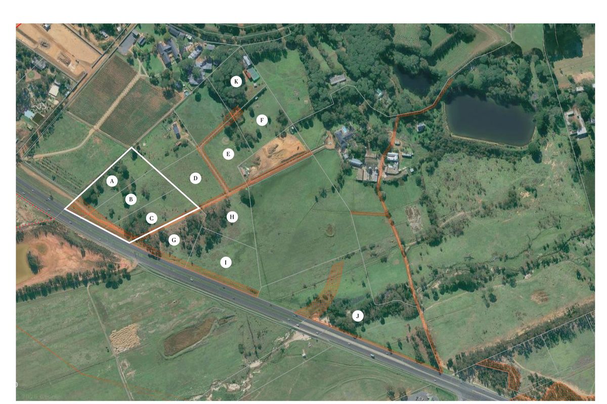 Aerial view of a vacant residential land plot with boundary lines clearly marked, situated in a rural landscape setting.