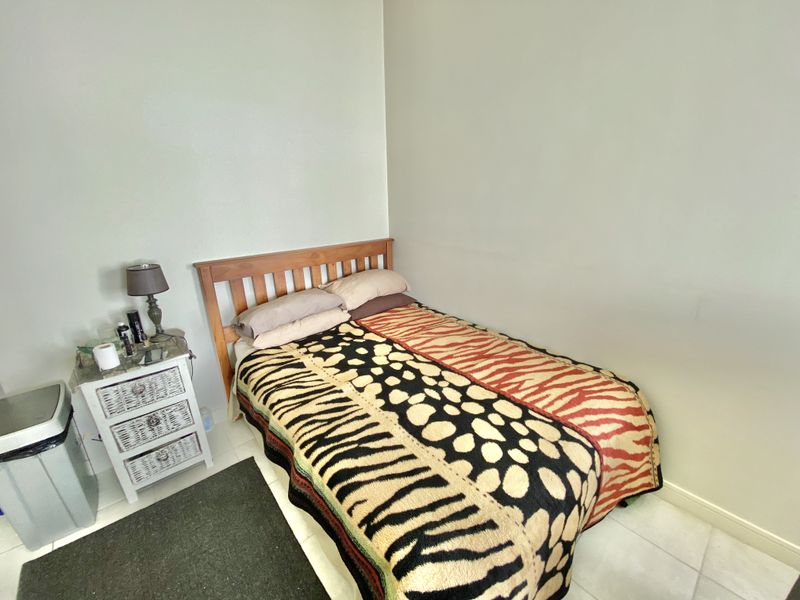 A standard bedroom featuring tiled flooring and neutral wall finishes, providing a functional space for rest.