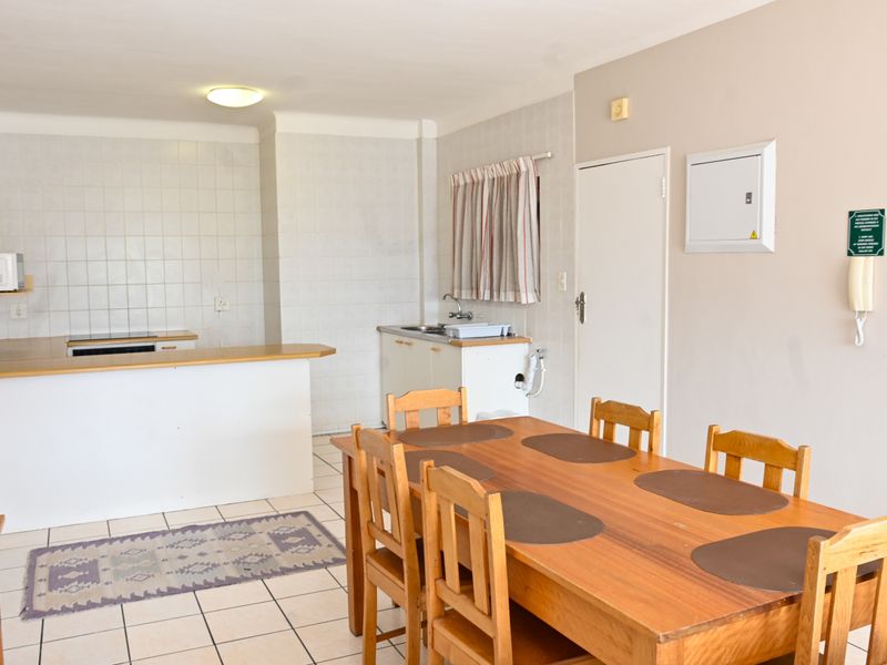 Open-plan kitchen and dining area featuring tiled flooring, built-in cabinetry, and a functional layout suitable for modern updates.
