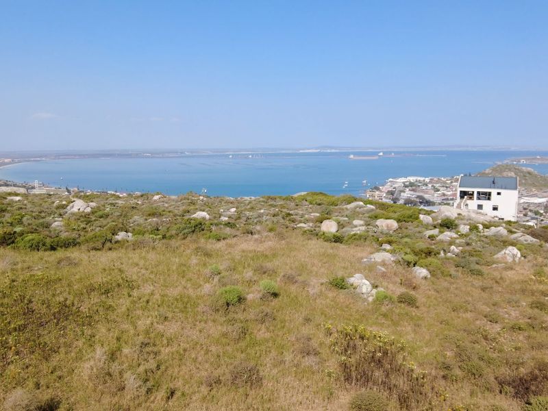Elevated view overlooking the coastal landscape, bay, and surrounding residential area, showcasing the natural terrain and scenic outlook.