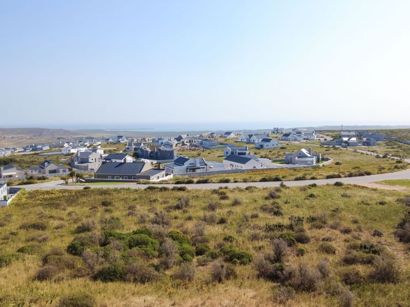 An aerial view of a residential estate featuring paved roads and surrounding natural landscape.