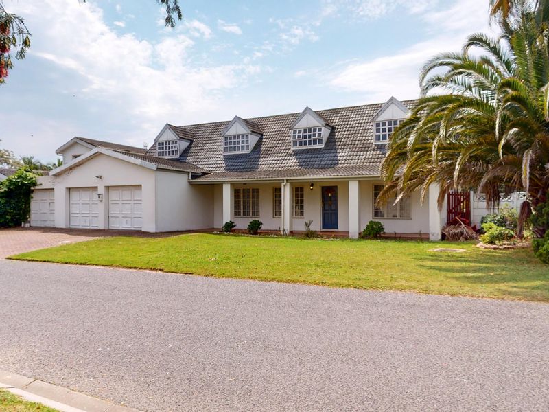 Front elevation of a traditional house featuring a tiled roof with dormer windows, a covered porch, and an attached double garage.