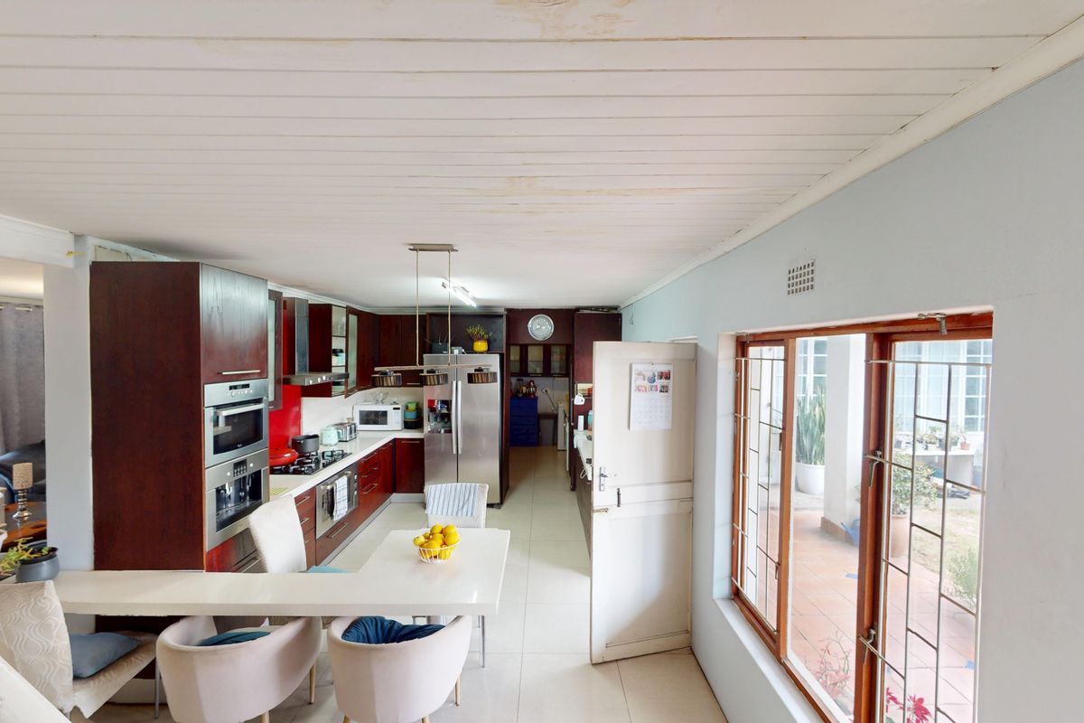 Spacious kitchen featuring dark wood cabinetry, built-in appliances, and tiled flooring, with direct access to an outdoor patio area.