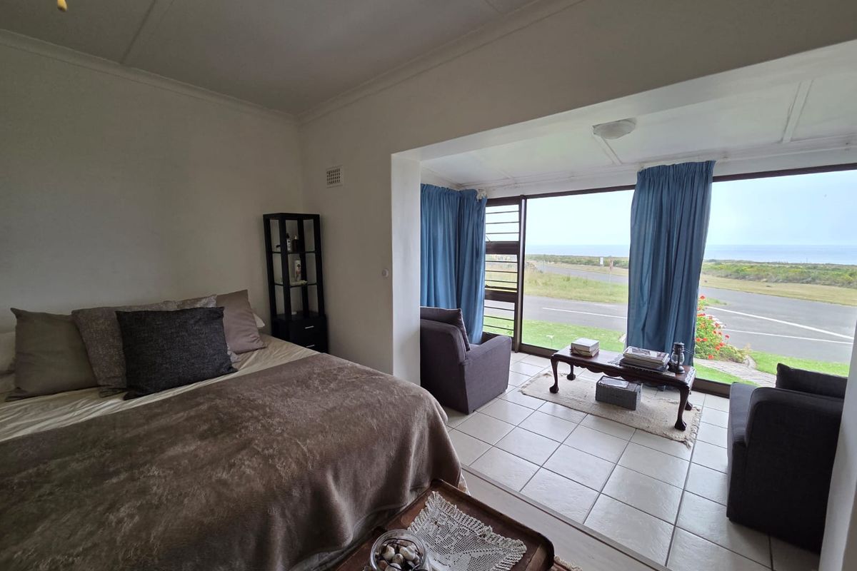 A bedroom featuring tiled flooring and large glass sliding doors that provide expansive views of the surrounding landscape.
