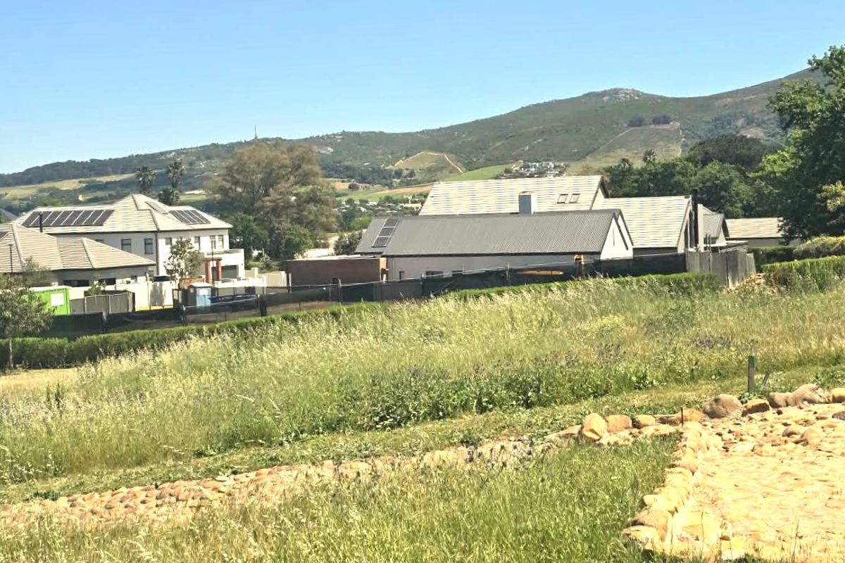 A scenic view overlooking a residential estate with surrounding mountain vistas and established neighborhood homes.