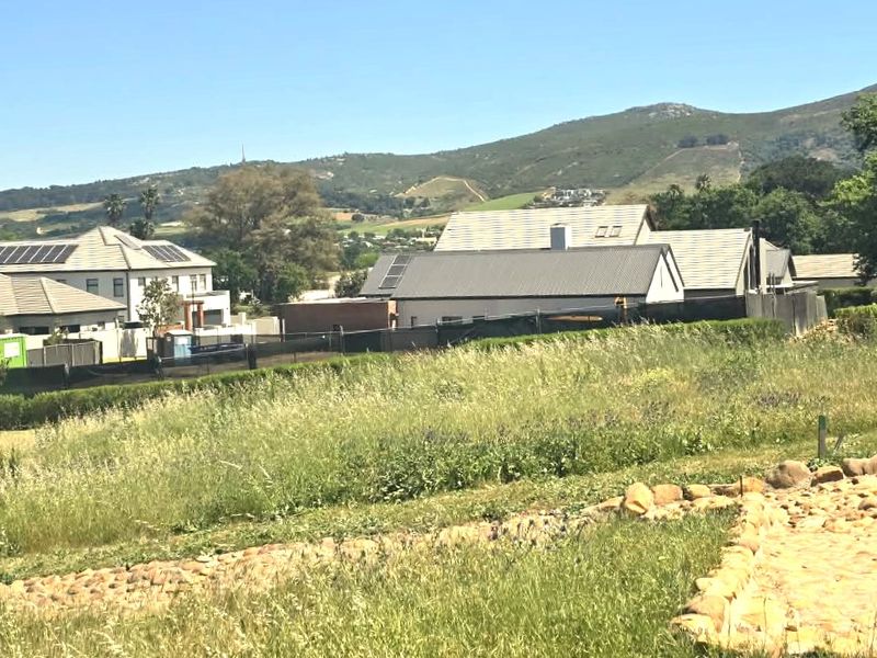 A scenic view overlooking a residential estate with surrounding mountain vistas and established neighborhood homes.