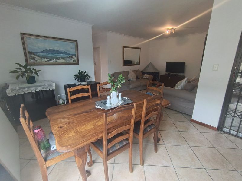 Open plan living and dining area featuring neutral ceramic floor tiles and direct access to an outdoor patio area.