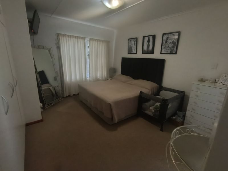 A standard bedroom featuring built-in cupboards and carpeted flooring, providing a functional space with neutral finishes.