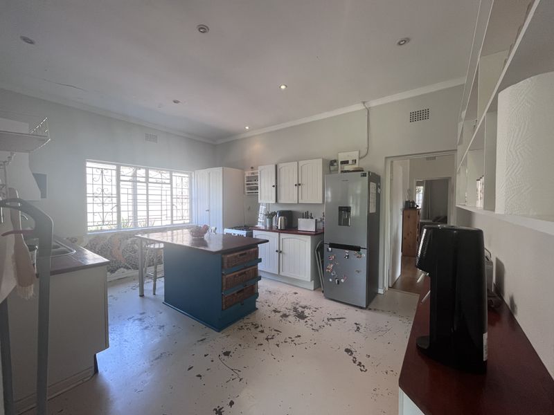 A kitchen featuring built-in cabinetry, a central island, and recessed lighting. The space requires flooring and ceiling repairs to improve its overall condition.