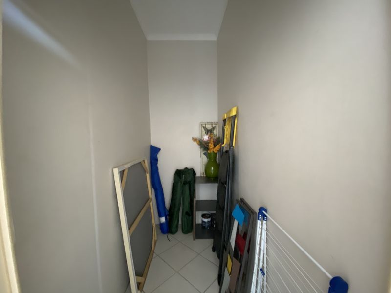 A small, neutral-toned utility space or storage closet featuring tiled flooring, suitable for organization or additional storage needs.